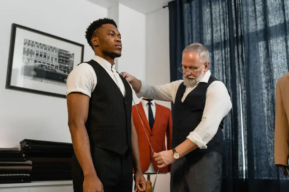 Master tailor taking precise measurements for a custom bespoke garment